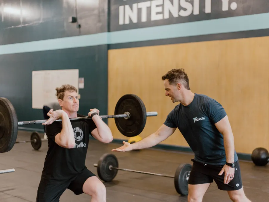 CrossFit Spring Hill coach guiding a member through a front squat during class