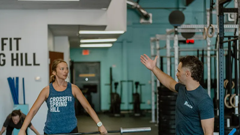 Coach working one-on-one with a member during a personal training session at CrossFit Spring Hill
